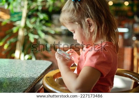girl play phone in cafe during waiting food