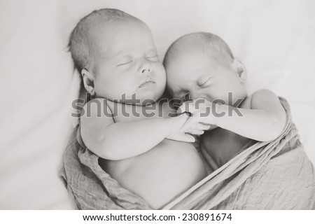 sleeping  sweet twins with hand in hand