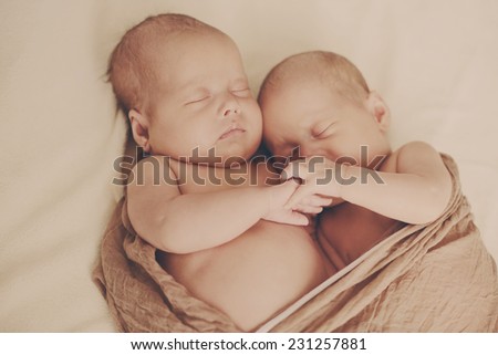 sleeping  sweet twins with hand in hand
