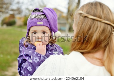 baby on the mother hands eating cake