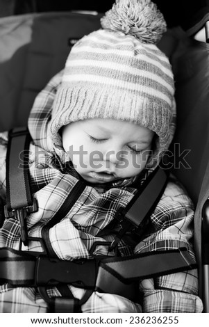 baby boy sleeping in the red stroller
