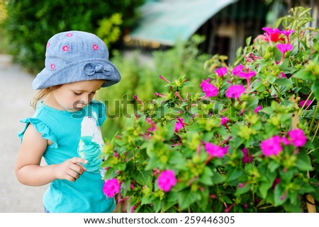 toddler girl near flowers in the garden