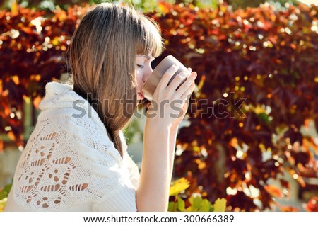 girl with mug of hot drink in sunny fall day