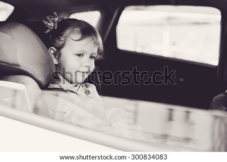 child in car in seat with belt on shoulder