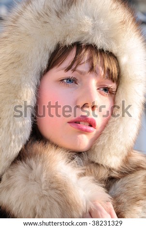 pretty girl with blue eyes is wearing winter fur cap
