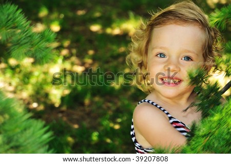 she is cute, smiling blond girl, she is happy to be in forest
