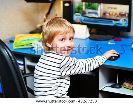 little boy playing computer games at home