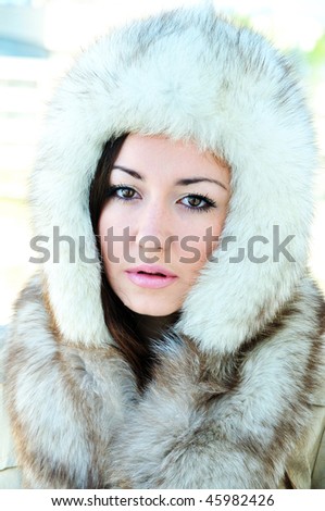 pretty brunette with hazel eyes is wearing winter fur cap