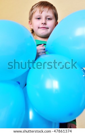 funny boy holding a lot of  blue balloons