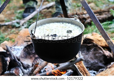 kettle with soup on fire in spring forest