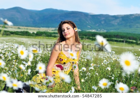girl relaxing in the daisy field with flower in her hair