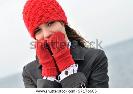 girl wearing  reg hat and red gloves outdoors