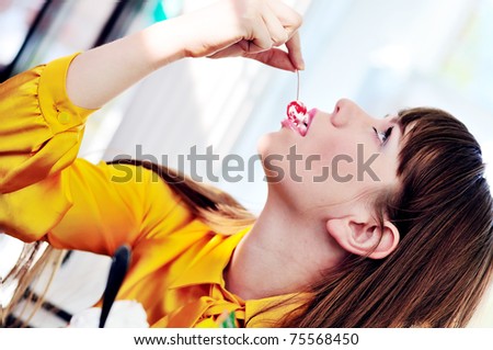 longhaired girl enjoying dessert with cherry in  cafe