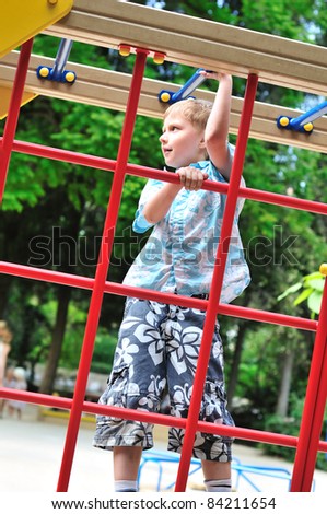 boy climbing wall bars on the playground