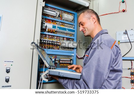 electrician testing industrial machine, electrician builder engineer screwing equipment in fuse box, Male Electrician,energy conservation, electrical work, repair of electricity\power station,electric