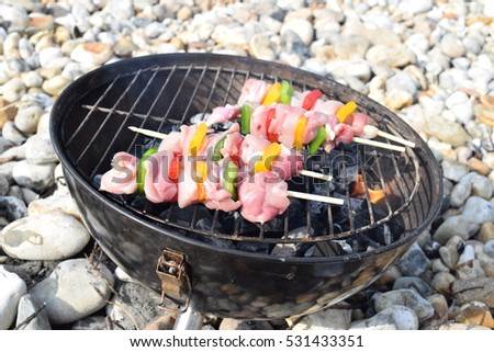 Raw shish kebabs barbecuing on the beach