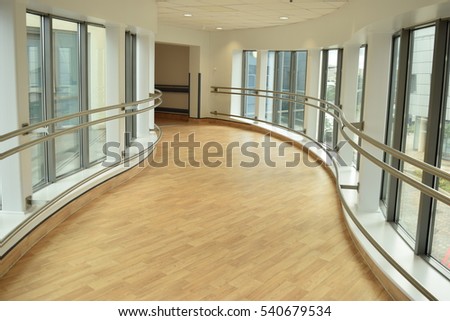 Long bright hallway in a hospital with railing to hold
