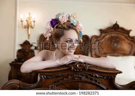 Gorgeous woman in bride dress having a large bun with artificial flowers.