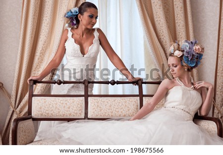 Lovely brides in a hotel room having a large flowers bun hair.