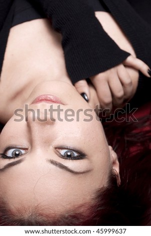 Fashion red haired girl looking at camera while hugging self. Focus on eyes.