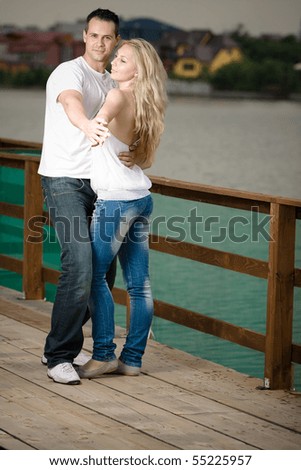Lovely couple smiling and dancing on a boat-house.