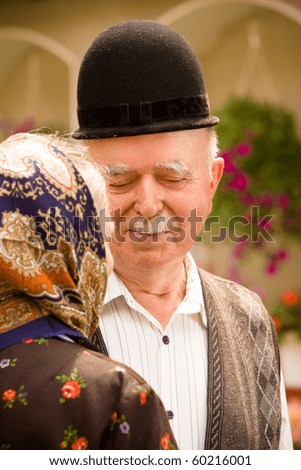 Portrait of a very old couple at country side smiling and having fun. See more images with them.