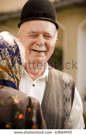 Portrait of a romanian traditional very old couple on country side. Focus on the man\'s face expression. See more images with them.
