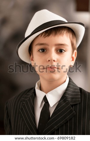 Portrait on a lovely boy with attitude in a black tuxedo with shirt and tie. See other images.