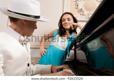Lovely young lady admiring his boy performing at a grand piano. Please see more images from the same shoot.