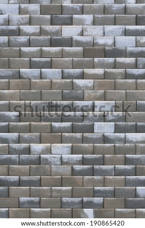 Grey bright dark brown wet weathered decorative abstract brick wall texture closeup, old rough grunge textured gray deco concrete tile bricks background grungy stained tiled brickwork vertical pattern