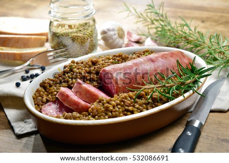 Cotechino with lentils with rosemary served on a plate with some ingredients