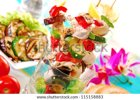 chicken and vegetable skewers served in glass  with grilled aubergine and zucchini salad