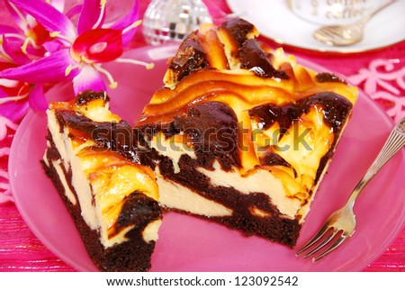 black and white cheese cake with wavy layer of poppy on pink plate