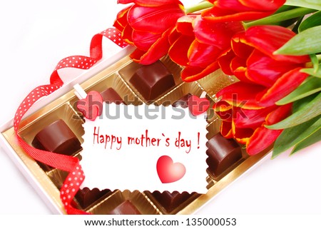 red tulips and box of chocolates with greeting card as gift for mother