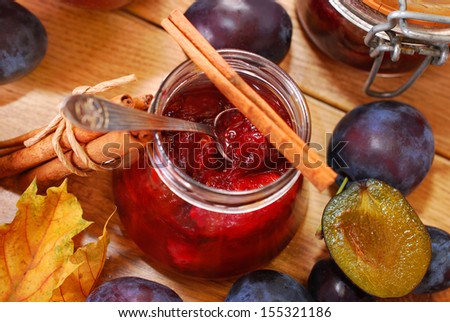 Jar Of Homemade Plum Jam With Cinnamon And Fresh Fruits On Wooden Table - Top View