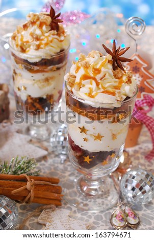 christmas dessert with gingerbread,whipped cream,caramel,plum and walnuts in glass