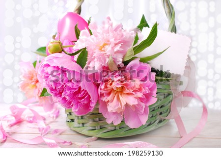 beautiful pink peony in wicker basket with blank card (shallow focus)