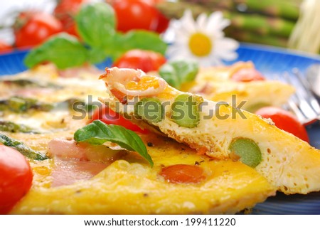 frittata with green asparagus,prosciutto ham and grilled cherry tomato on blue plate