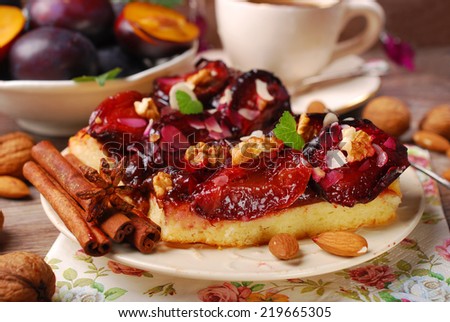 piece of homemade plum cake with nuts and spices,fresh fruits  and cup of coffee