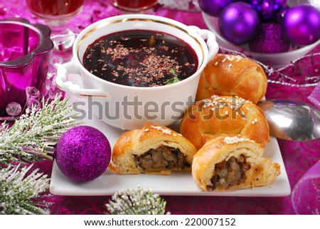 cup of traditional red borscht and yeast pastries with mushrooms filling for christmas eve