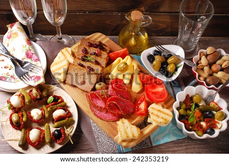 mediterranean appetizers and antipasti with olives,mozzarella,dried tomatoes on wooden table