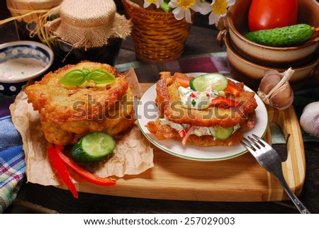 homemade fried potato cakes with vegetable and mayonnaise sauce on rustic table