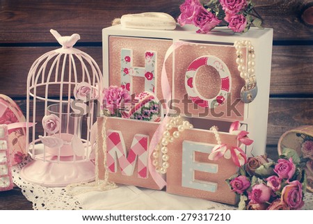 vintage home still life with wooden drawers box,pink cage and roses in romantic style