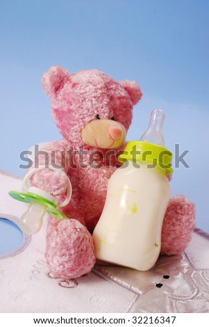 bottle of milk for baby and pink teddy bear