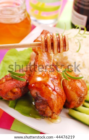 baked chicken legs with honey and soy sauce-focused on spoon