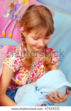 little girl playing with her baby doll pretending mom