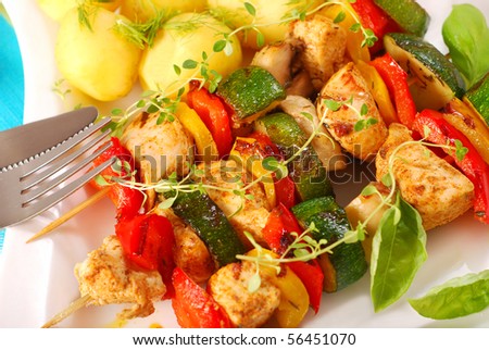grilled chicken and vegetables skewers with potato for dinner