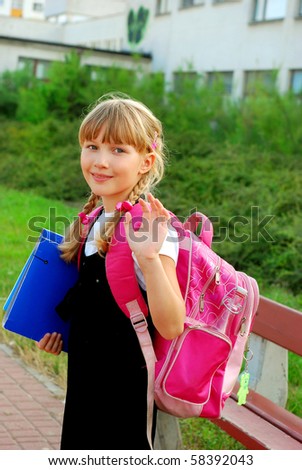 young girl with pink backpack going to school and waving hand to her parents