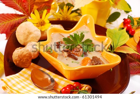 autumn mushroom soup with cream and vegetables in yellow leaf shape bowl