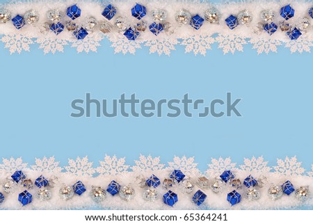 christmas border with snowflakes and small gift boxes lying in snow on blue background